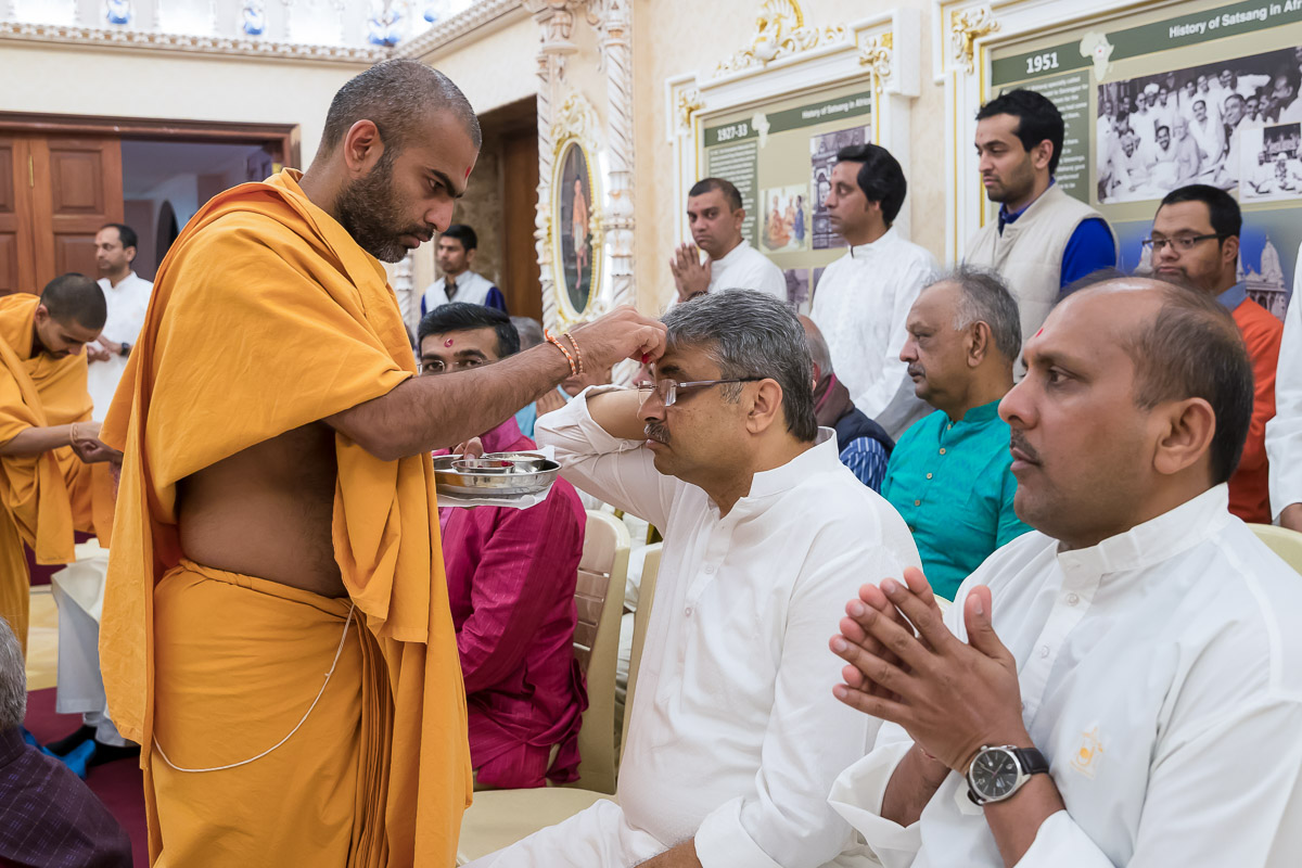 Sadhus applies chandlo to devotees