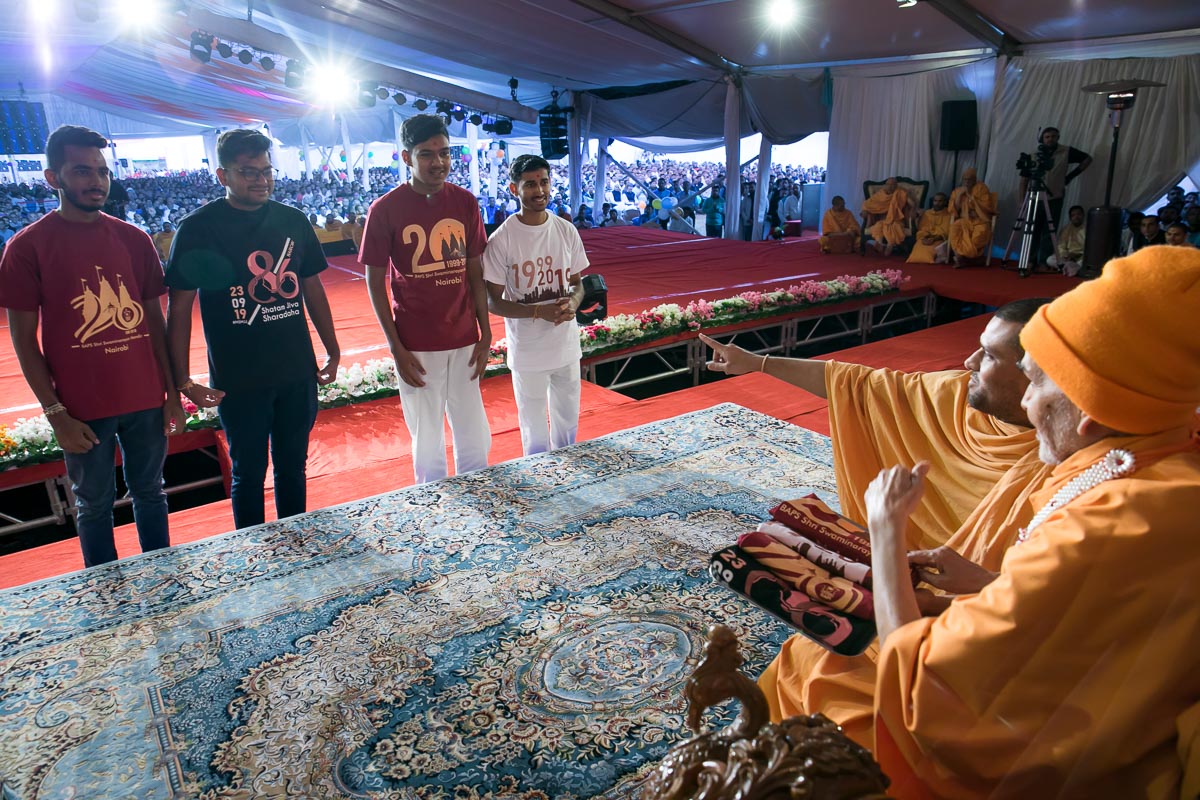 Swamishri observes mementos (tshirts)
