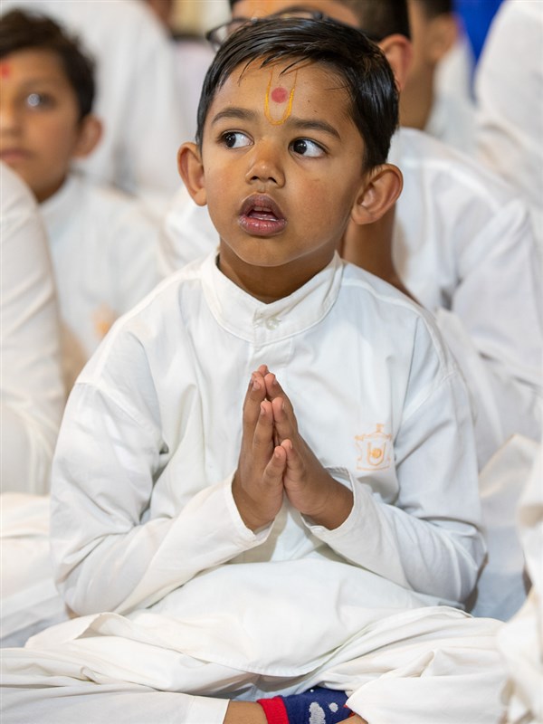 A child doing Swamishri's puja darshan