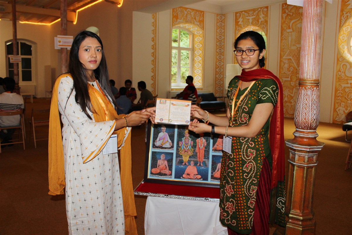 A delegate receives a prize for her outstanding Satsang Examination results