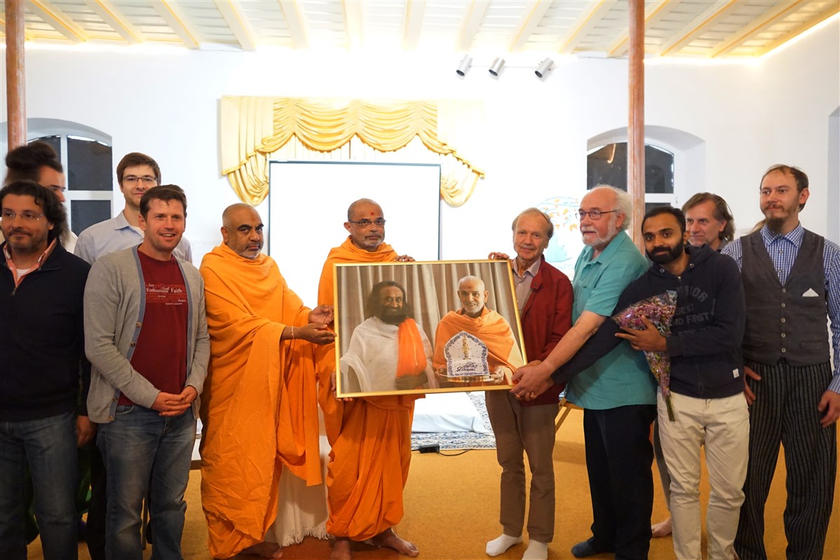 Swamis thank the ashram leaders with a photo of Mahant Swami Maharaj with Sri Sri Ravi Shankarji, founder of the Art of Living Foundation