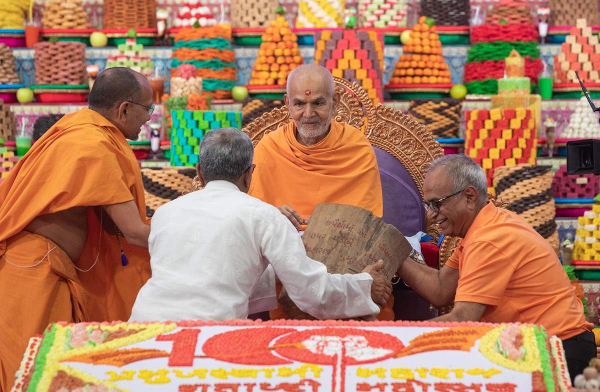 Swamishri presents a piece of wood from the tree sanctified by Ghanshyam Maharaj, for Swaminarayan Akshardham, Robbinsville NJ