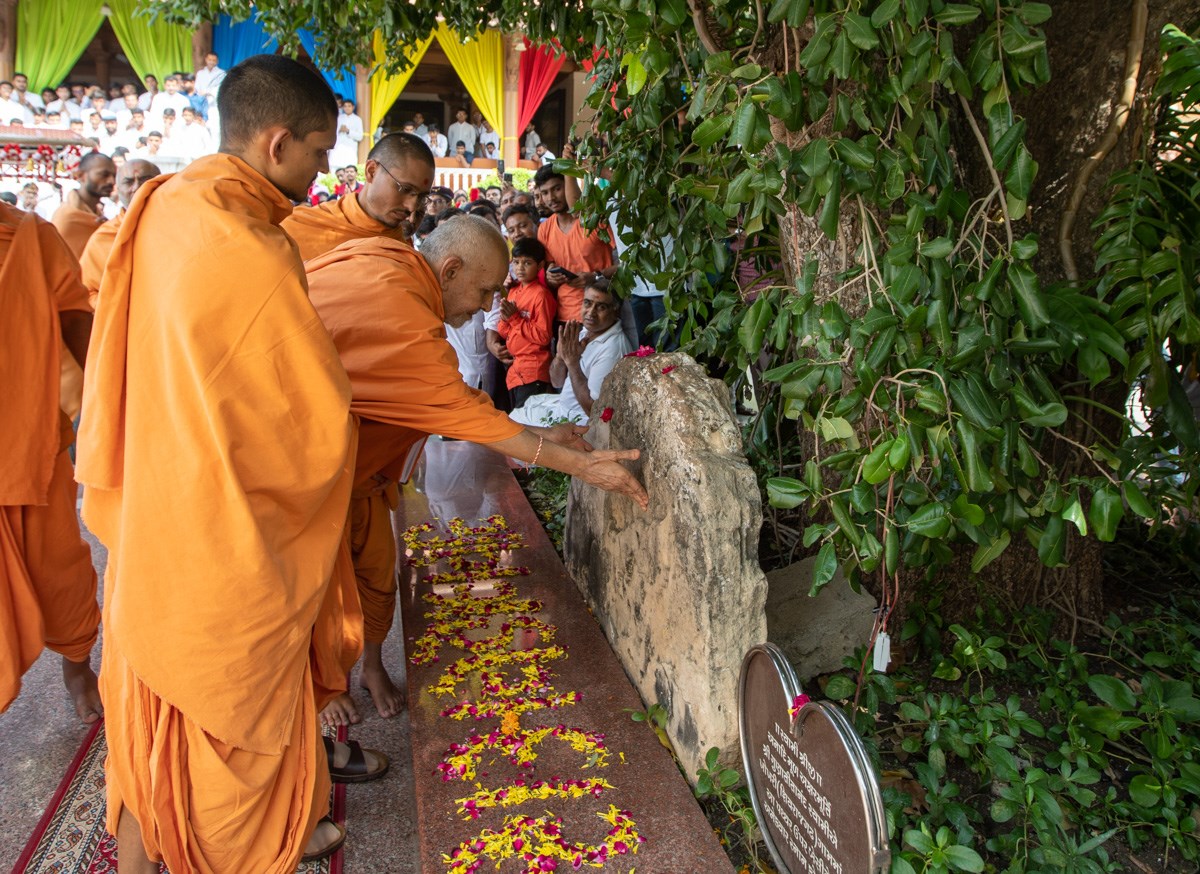 Swamishri engrossed in darshan of sacred stone sanctified by Aksharbrahman Gunatitanand Swami