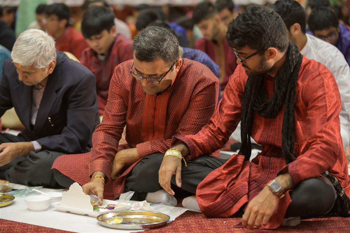 Devotees engaged in the Chopda Pujan rituals