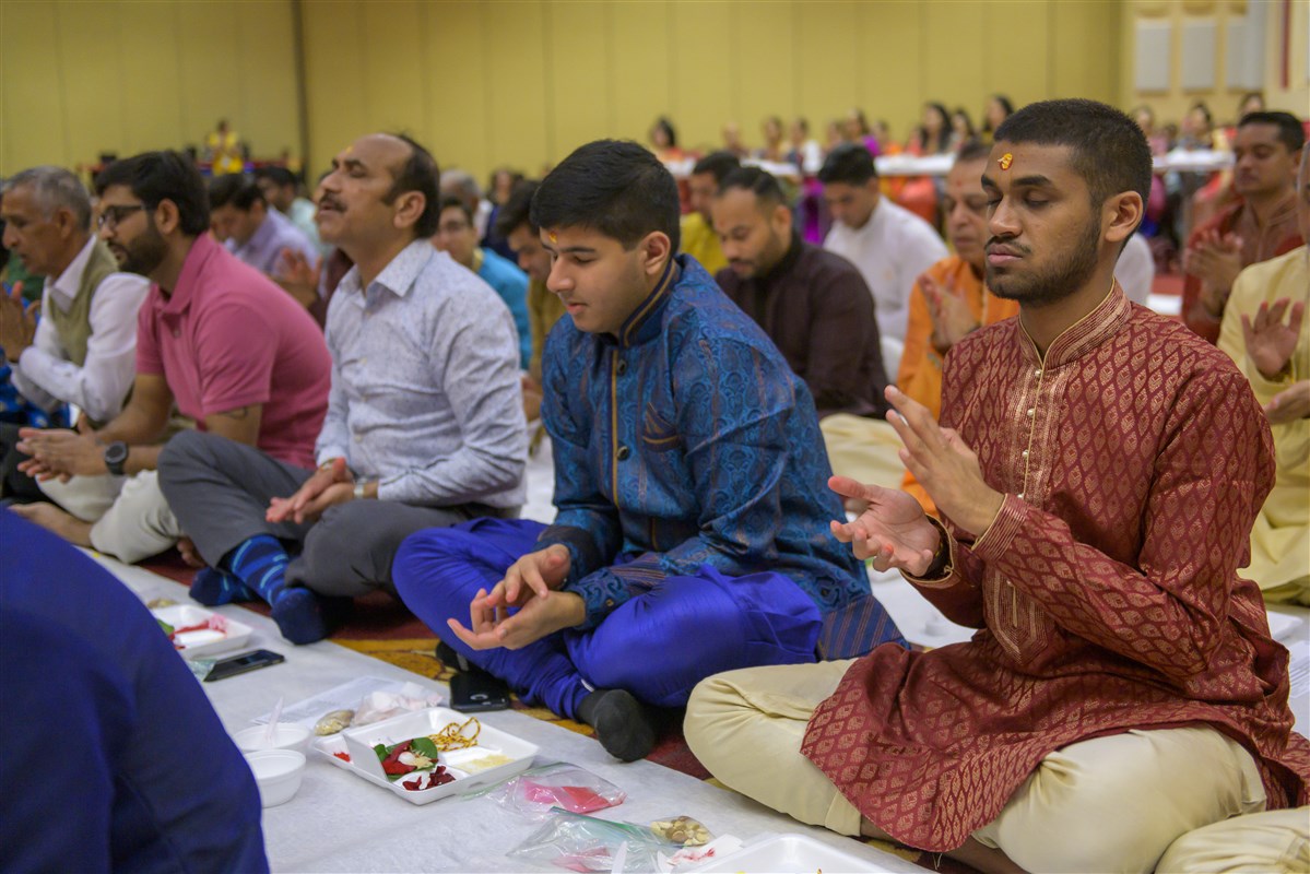 Devotees engaged in the Chopda Pujan rituals