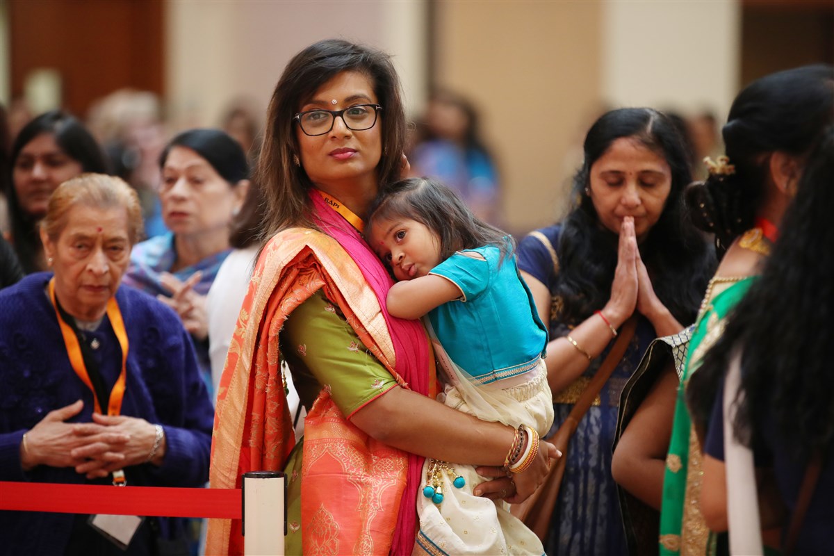 A mother and child engrossed in the darshan of the annakut