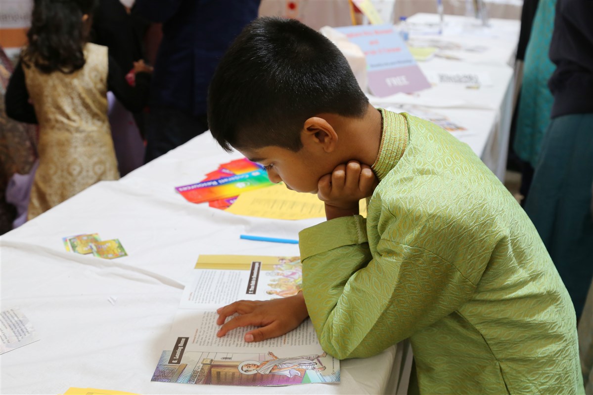 A young visitor is enraptured by a children's publication at the info stall