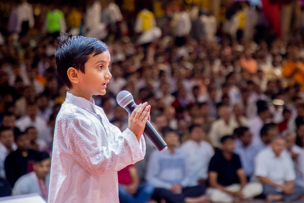 A child recites scriptural passages in Swamishri's puja