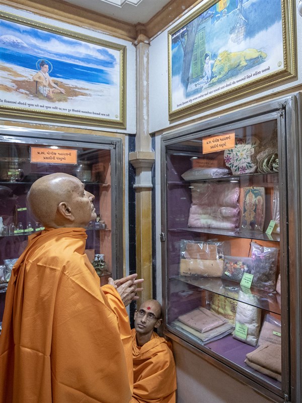 Swamishri observes a photo in the rang mandap