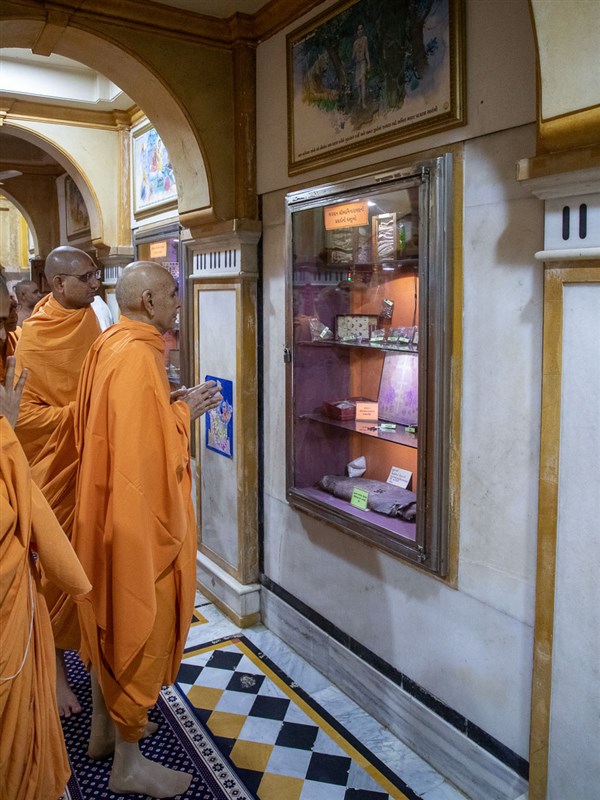Swamishri engrossed in darshan of the holy relics of Bhagwan Swaminarayan in the rang mandap