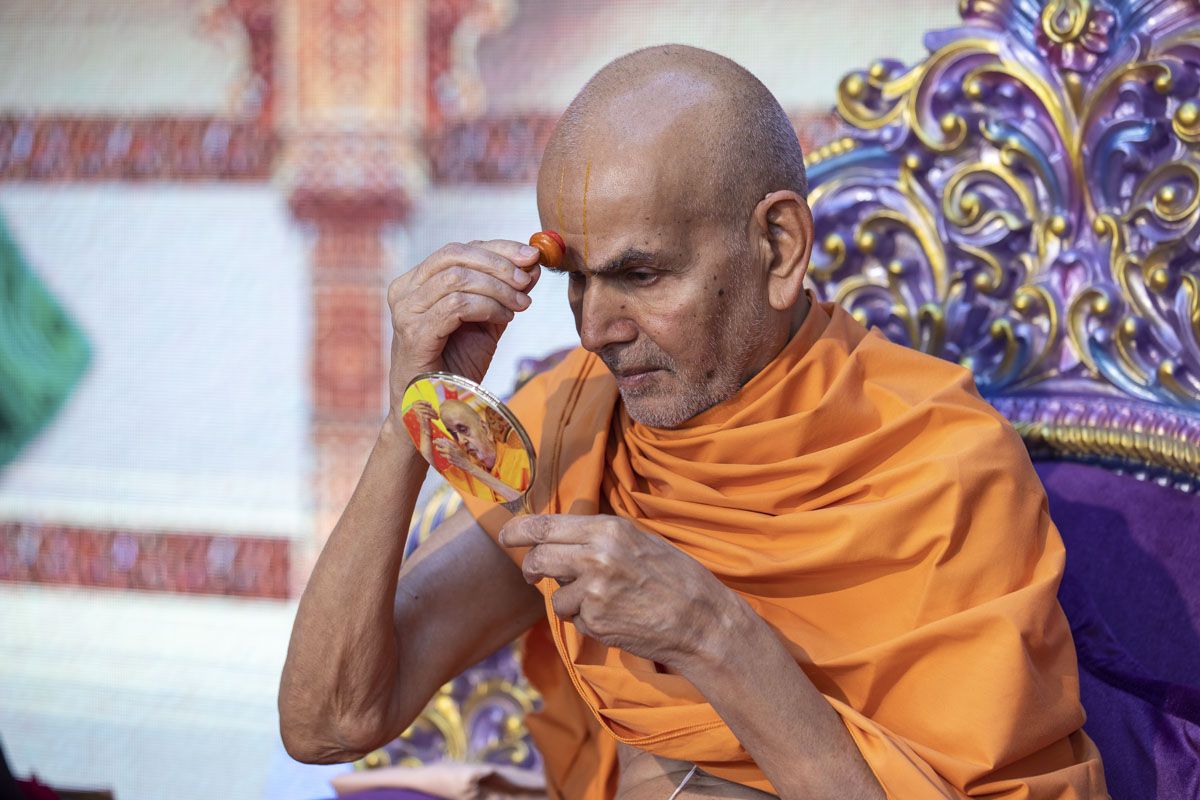 Swamishri applies chandlo on his forehead at the beginning of his daily puja