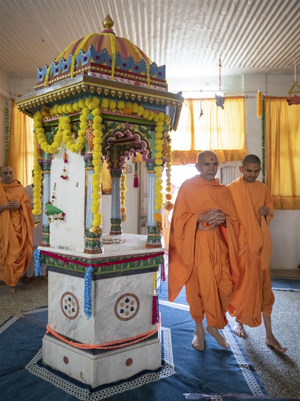 Swamishri performs pradakshina of the shrine of Purushottamdas Swami (Khandeshi)