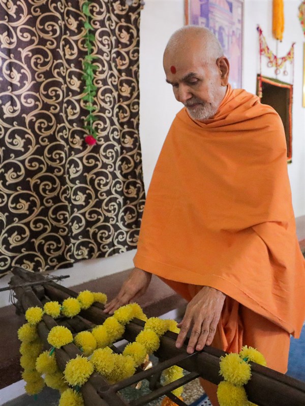 Swamishri reverentially touches a cart sanctified by Brahmaswarup Shastriji Maharaj