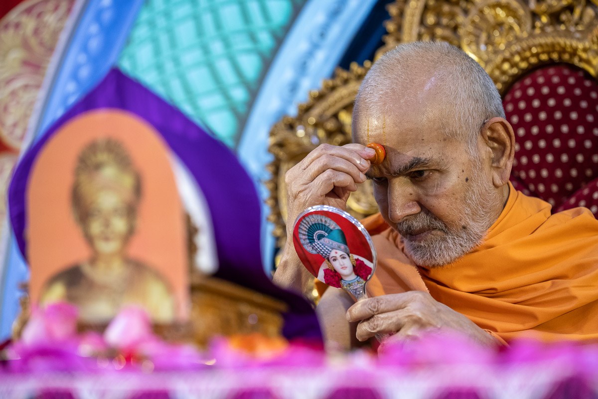 Swamishri applies chandlo on his forehead at the beginning  of his daily puja