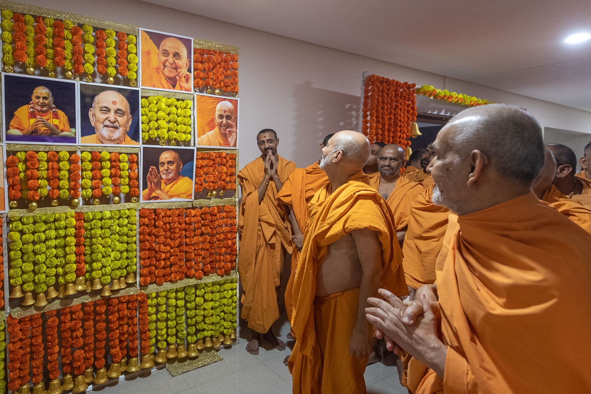Swamishri observes photos of Brahmaswarup Pramukh Swami Maharaj