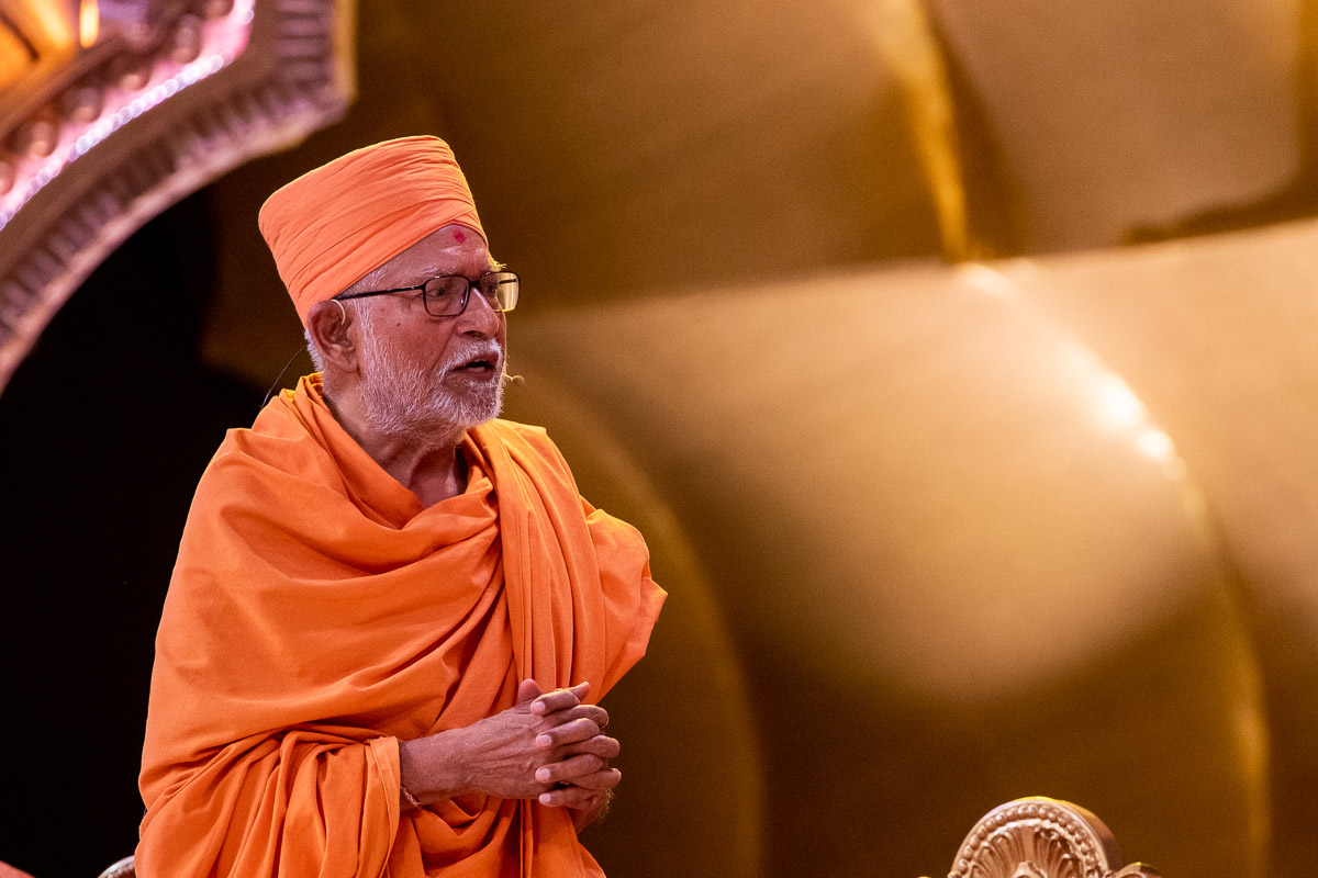 Pujya Kothari Swami recites a prayer before Swamishri on behalf of all