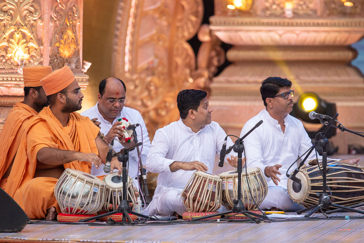 Sadhus and youths play instruments