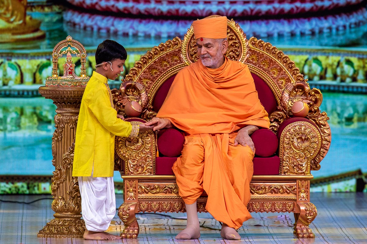Swamishri interacts with a child