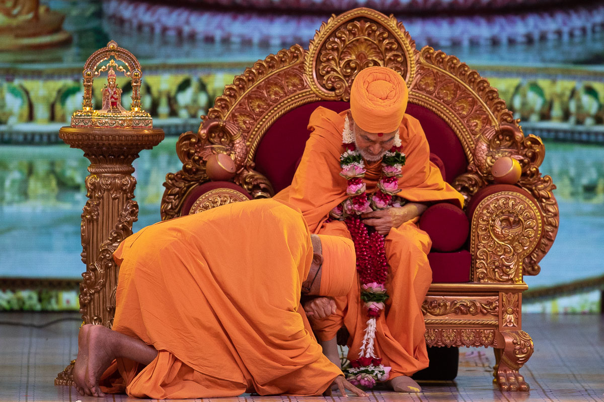 Pujya Kothari Swami honors Swamishri with a garland