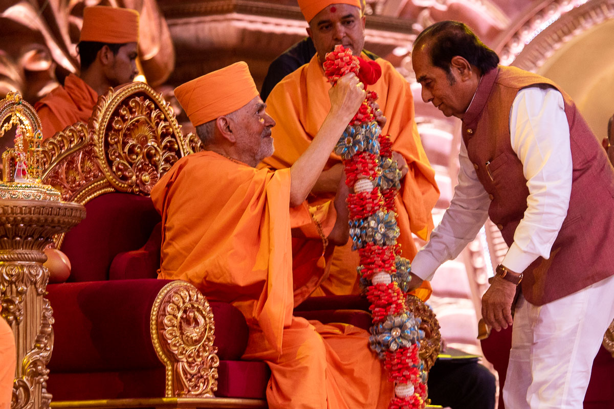 Swamishri honors Shri D.Y. Patil with a garland