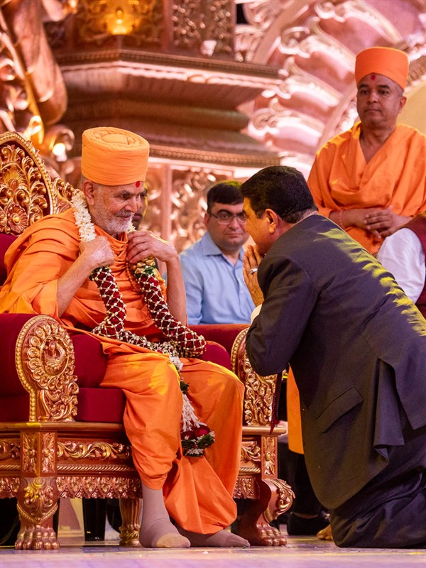 Shri B.R. Shetty honors Swamishri with a garland