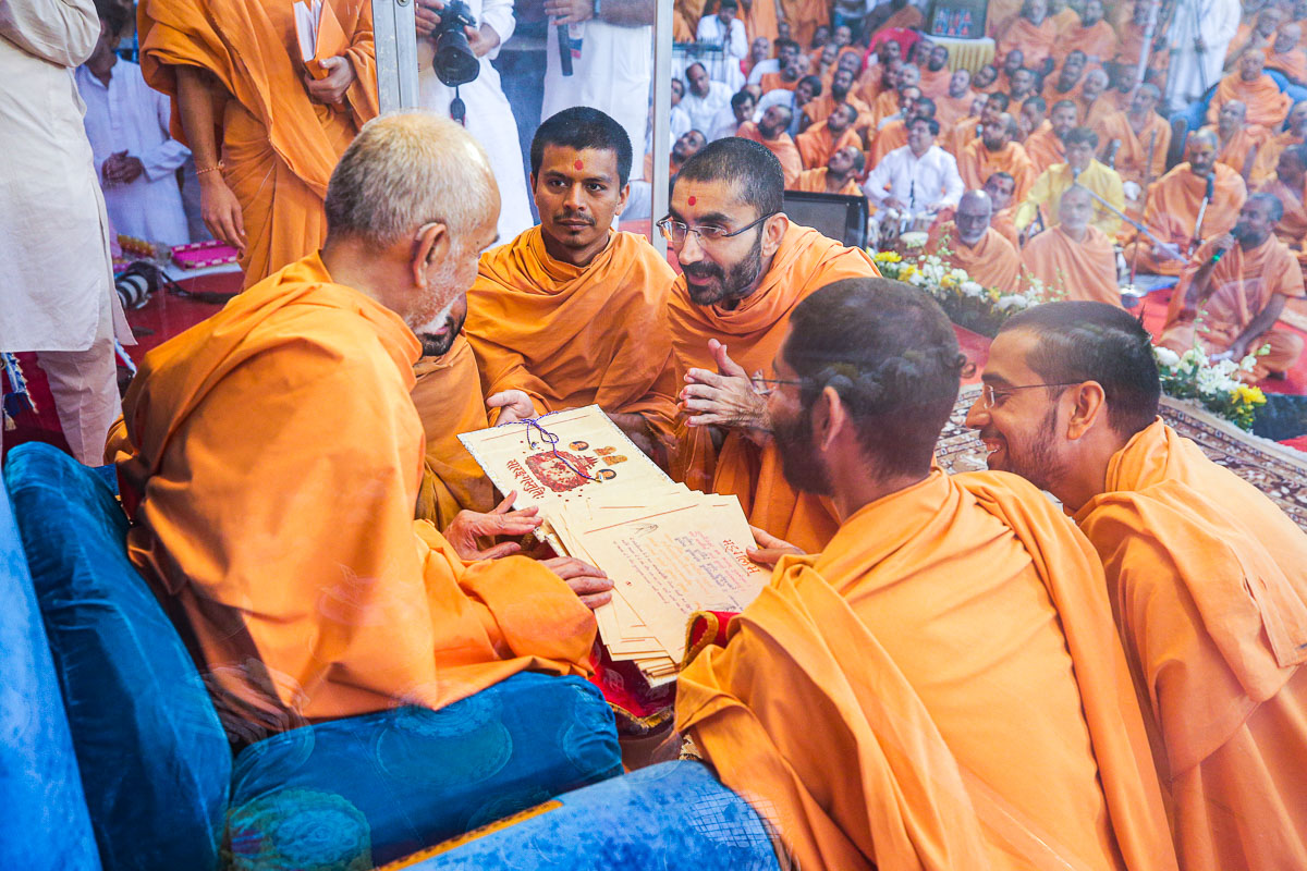 Swamishri sanctifies 'Sarangstuti', a handwritten book in honor of Pramukh Swami Maharaj's 98th birthday prepared by sadhus in Sarangpur