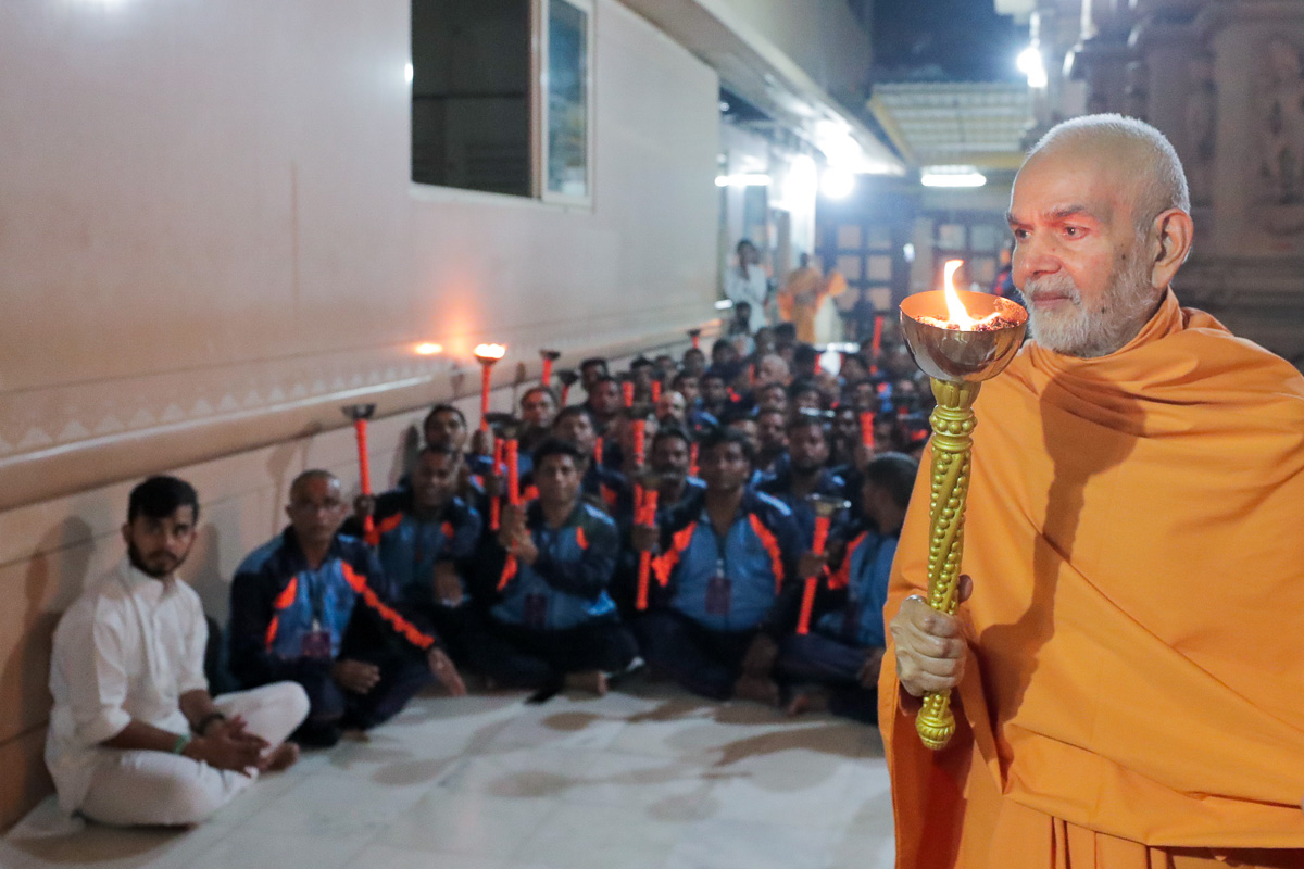Swamishri holds a mashal