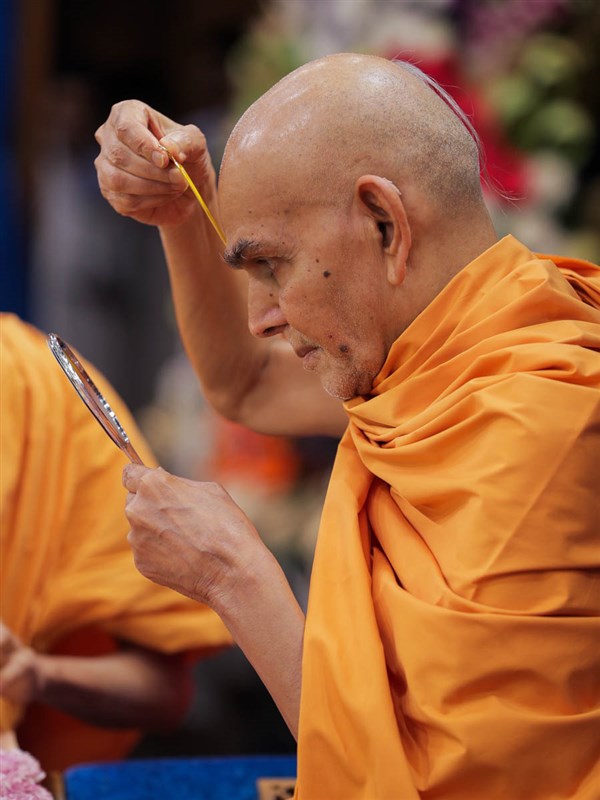 Swamishri applies tilak on his forehead at the beginning of his daily puja