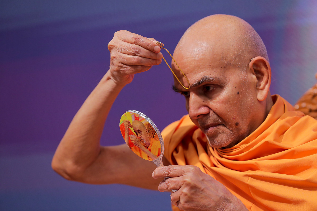 Swamishri applies tilak on his forehead at the beginning of his daily puja