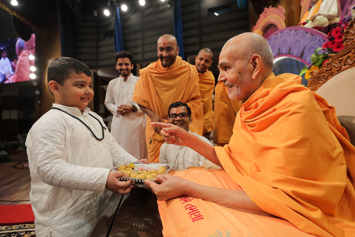 Swamishri interacts with a child