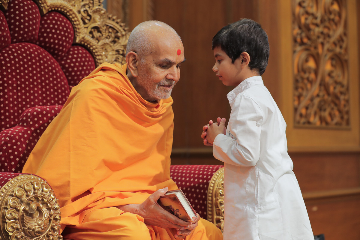 Swamishri listens to a child's prayers
