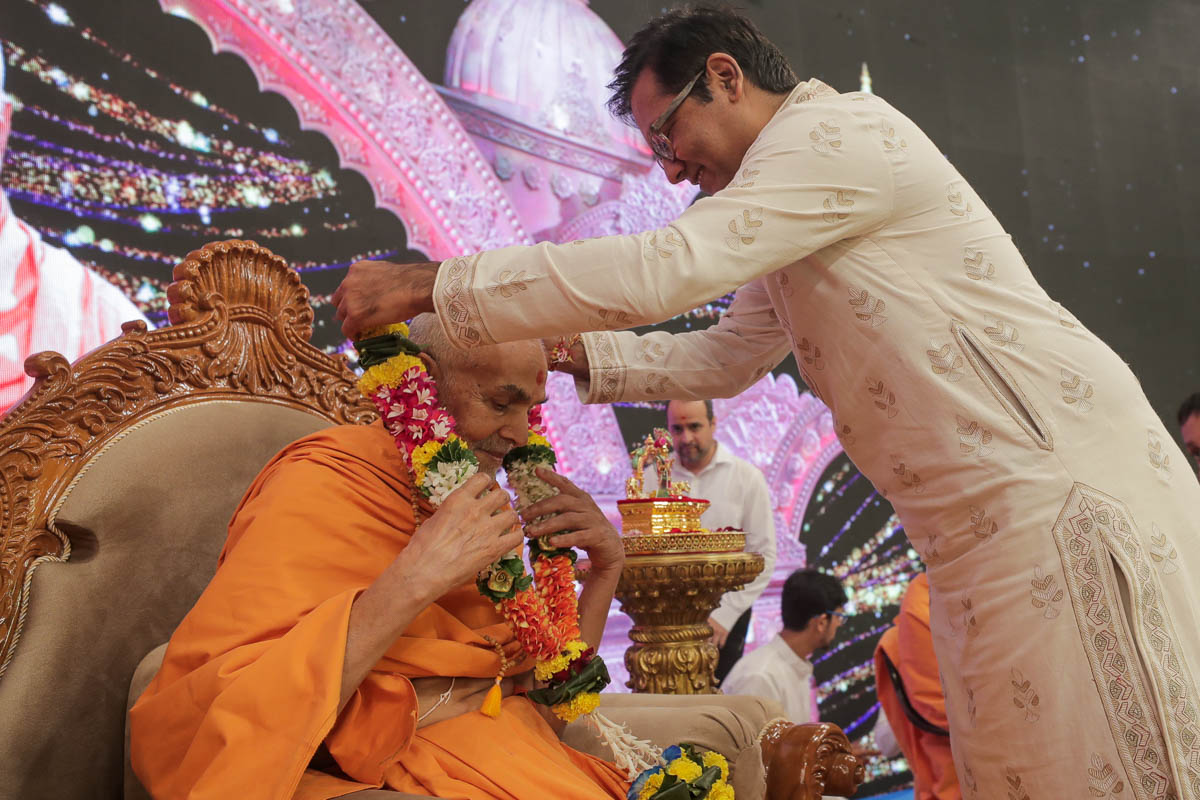 Shri Vijaybhai Patil honors Swamishri with a garland