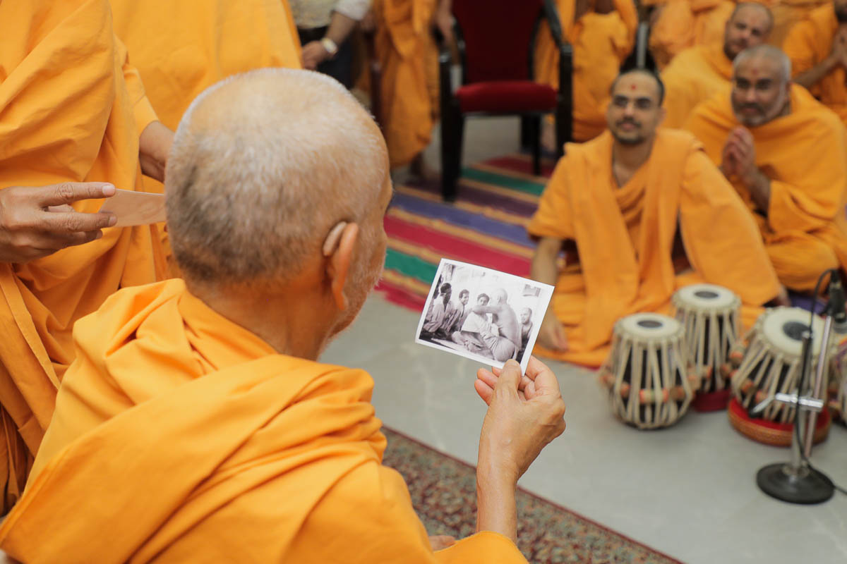 Swamishri observes old photos