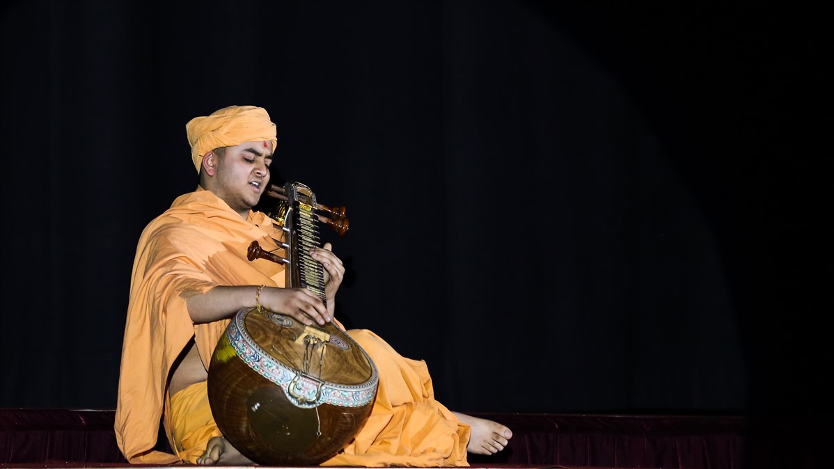 A paramhansa plays the sitar to accompany a devotional nighttime kirtan
