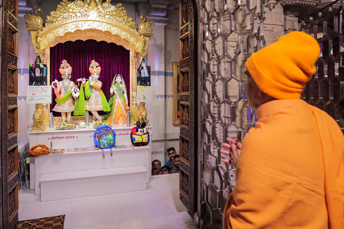 Swamishri engrossed in darshan of Shri Harikrishna Maharaj and Shri Radha-Krishna Dev