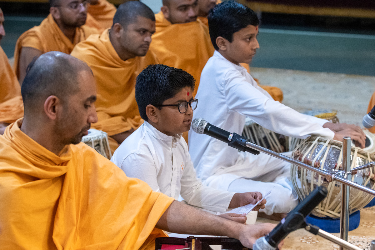 Children sing kirtans in Swamishri's morning puja
