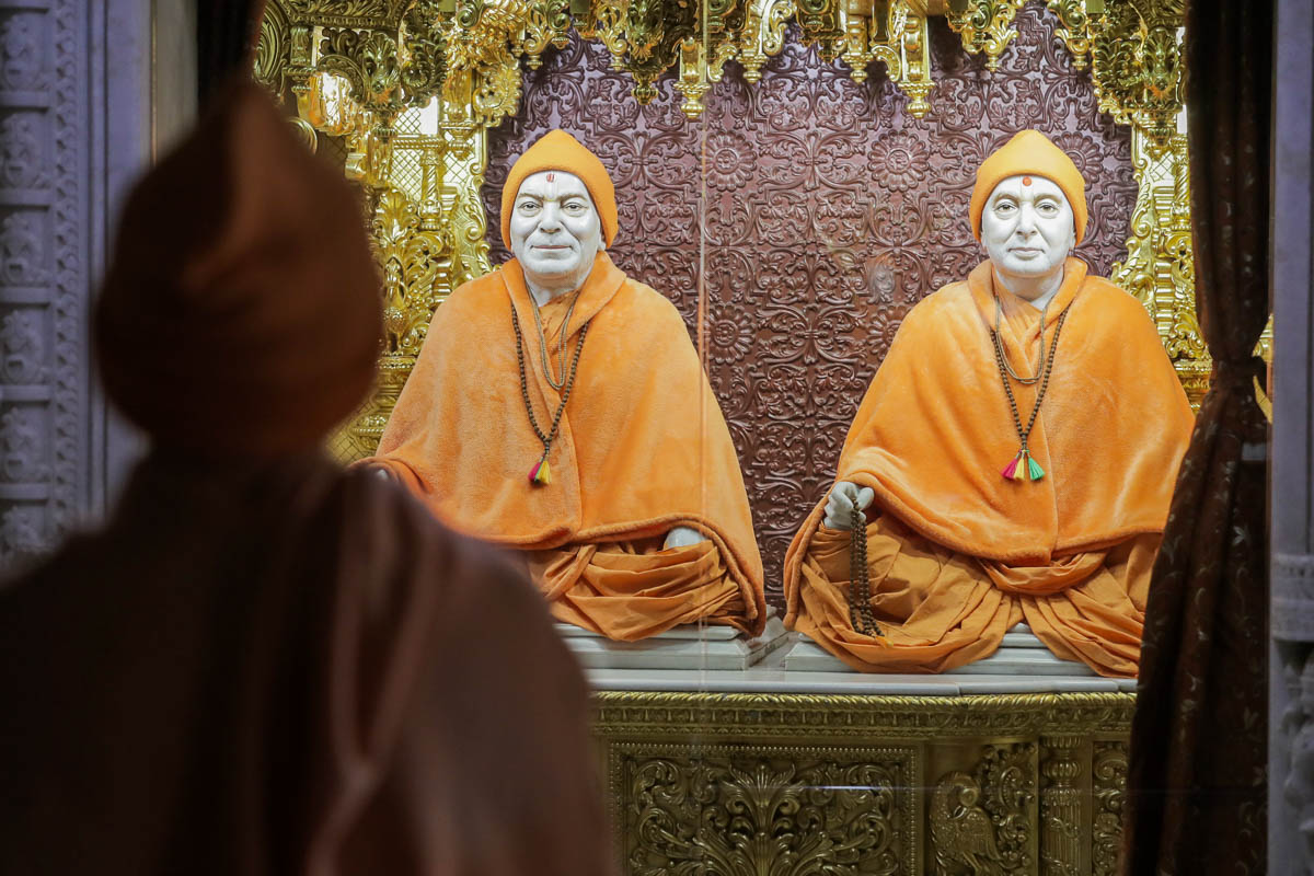 Swamishri engrossed in darshan of Brahmaswarup Yogiji Maharaj and Brahmaswarup Pramukh Swami Maharaj