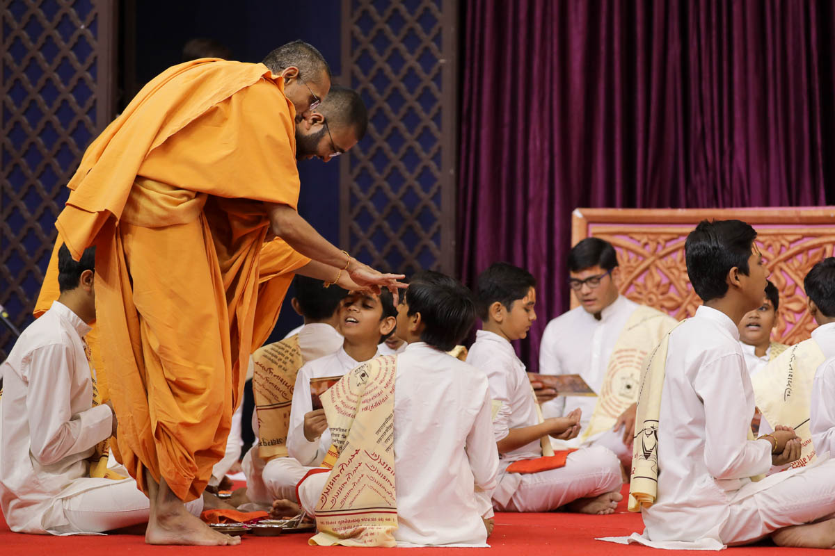 Sadhus apply chandlos to children at the beginning of the Swaminarayan mahapuja
