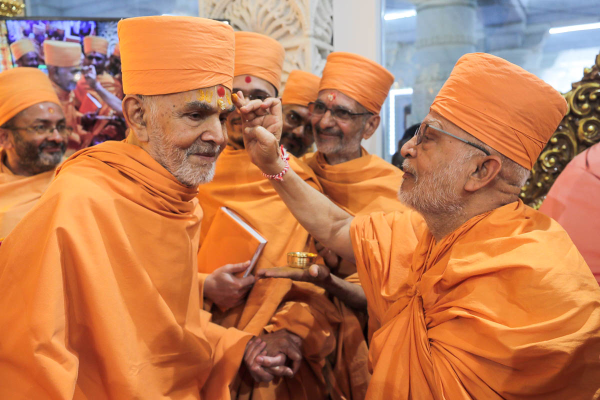 Ghanshyamcharan Swami applies chandan archa to Swamishri