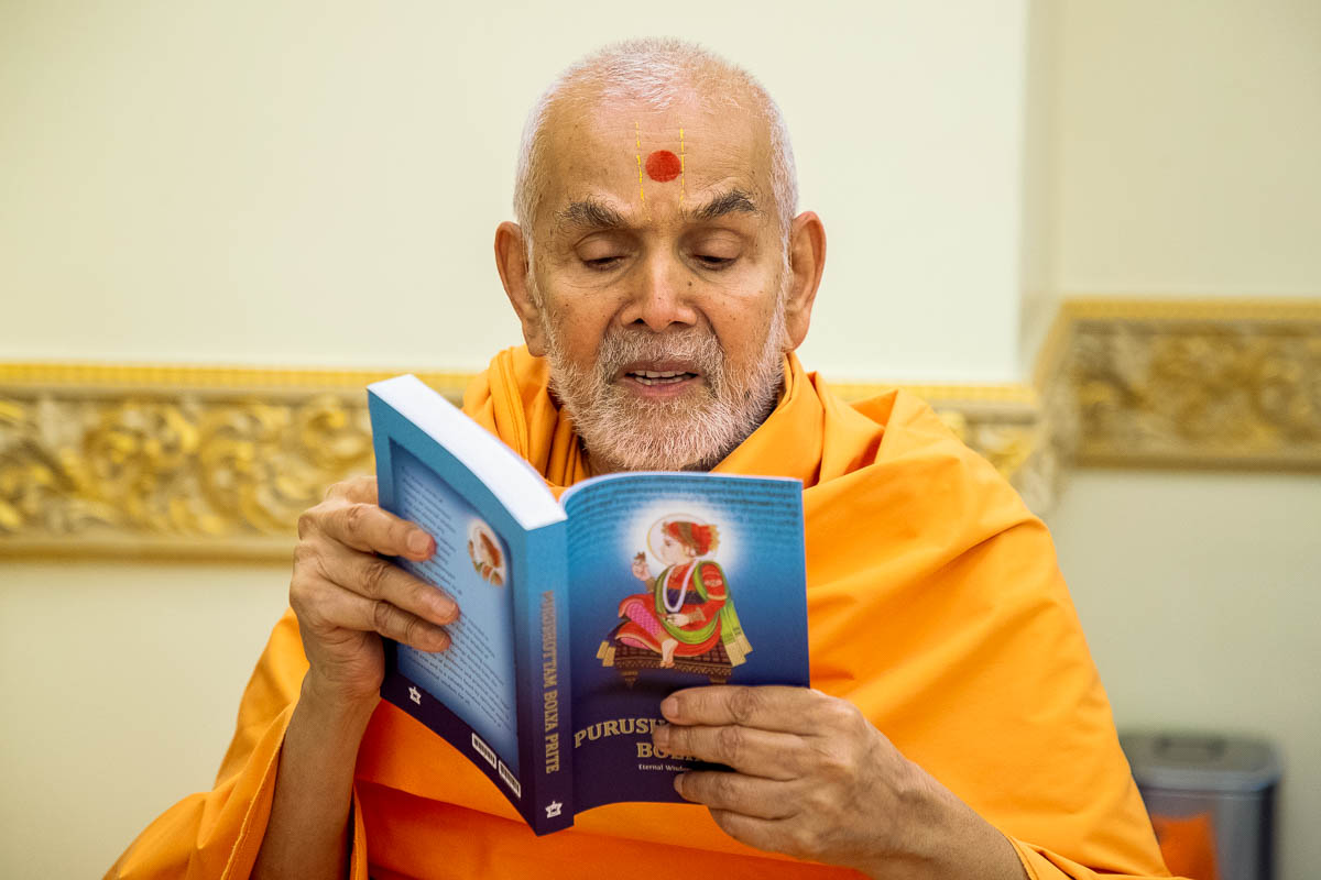Swamishri reads the English translation of 'Purushottam Bolya Prite'