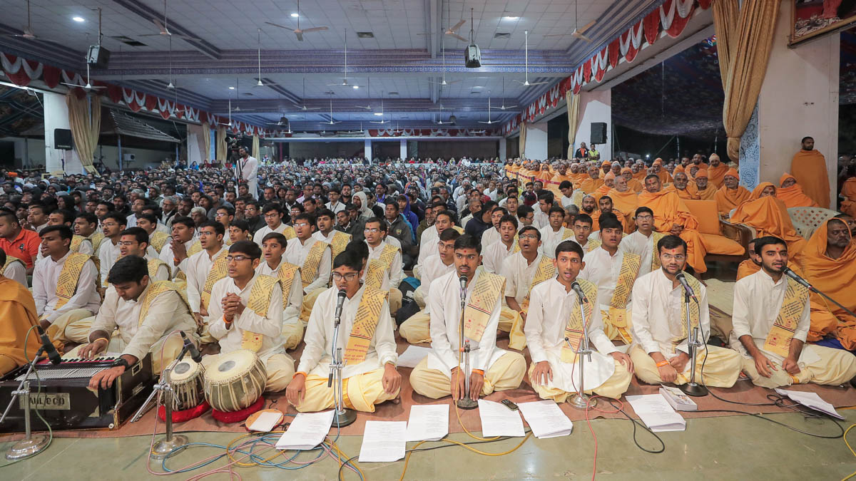 Youths sing scriptural verses in Swamishri's puja