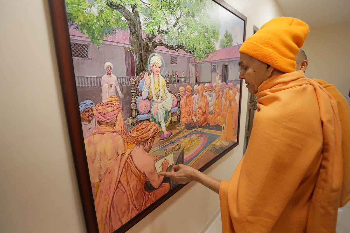 Swamishri observes a photo
