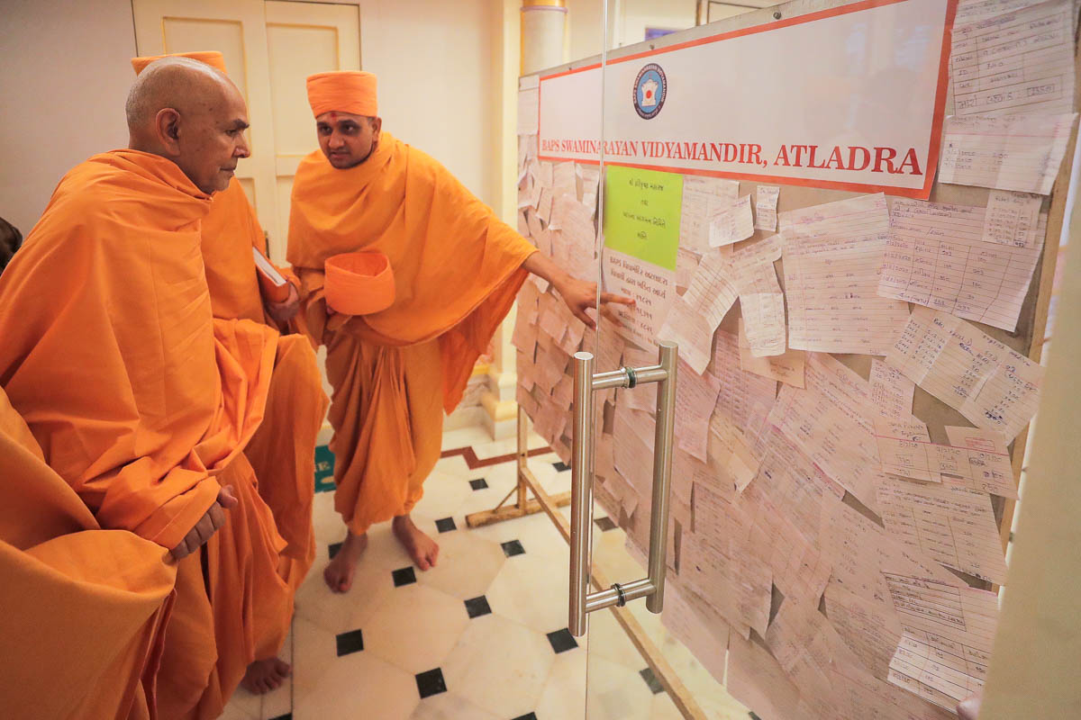 Swamishri observes message board of BAPS Swaminarayan Vidyamandir, Atladara