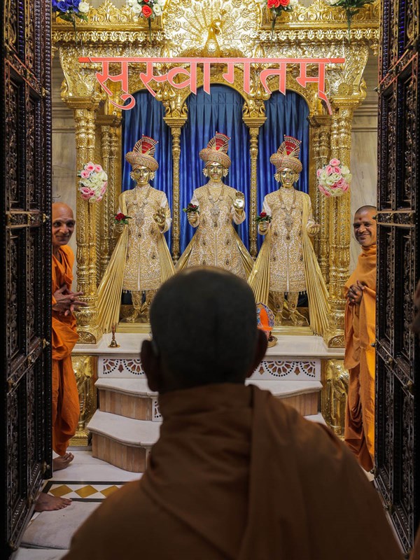 Swamishri engrossed in darshan of Bhagwan Swaminarayan, Aksharbrahman Gunatitanand Swami and Shri Gopalanand Swami
