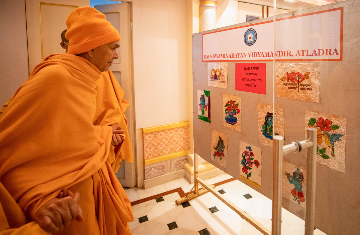 Swamishri observes paintings by students of the BAPS Swaminarayan Vidyamandir, Atladara