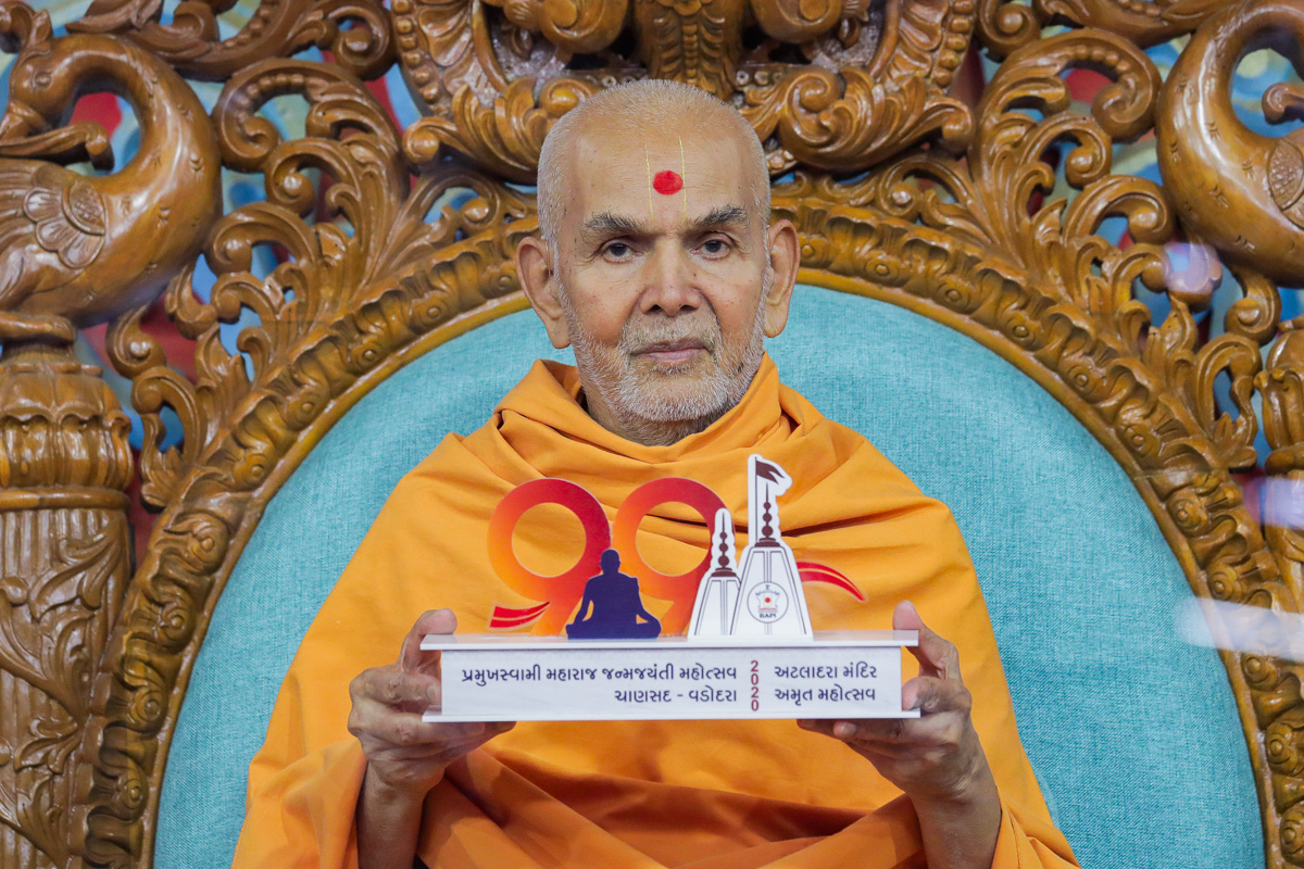 Swamishri sanctifies a gift item commemorating Pramukh Swami Maharaj's 99th Birthday Celebrations and the Amrut Mahotsav of Atladara Mandir 