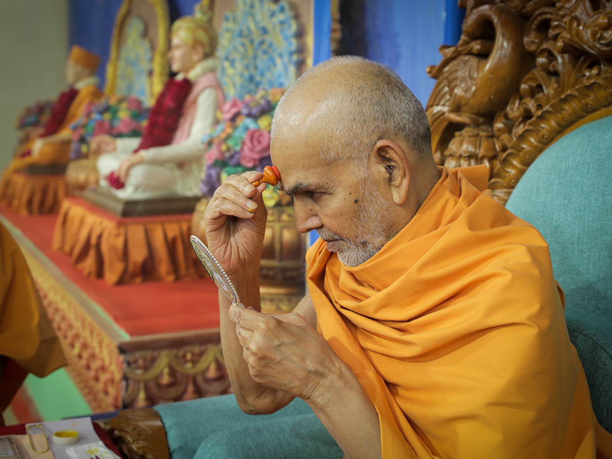 Swamishri applies chandlo on his forehead