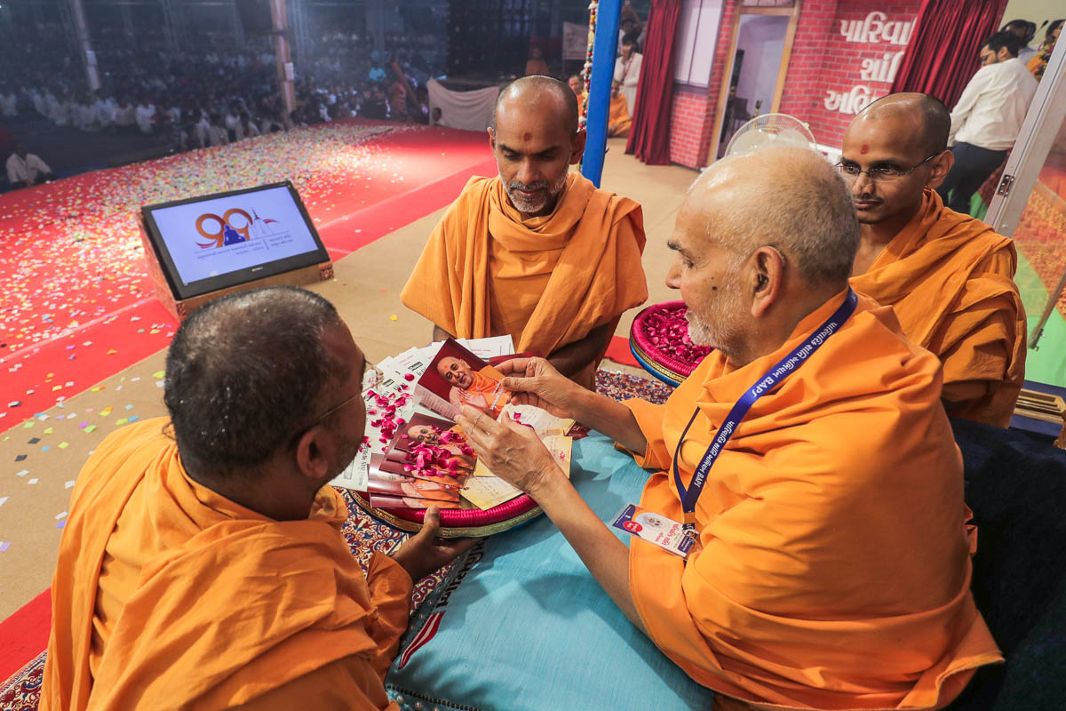 Swamishri sanctifies a booklet 'Viral Sant Vibhuti Pramukh Swami Maharaj'
