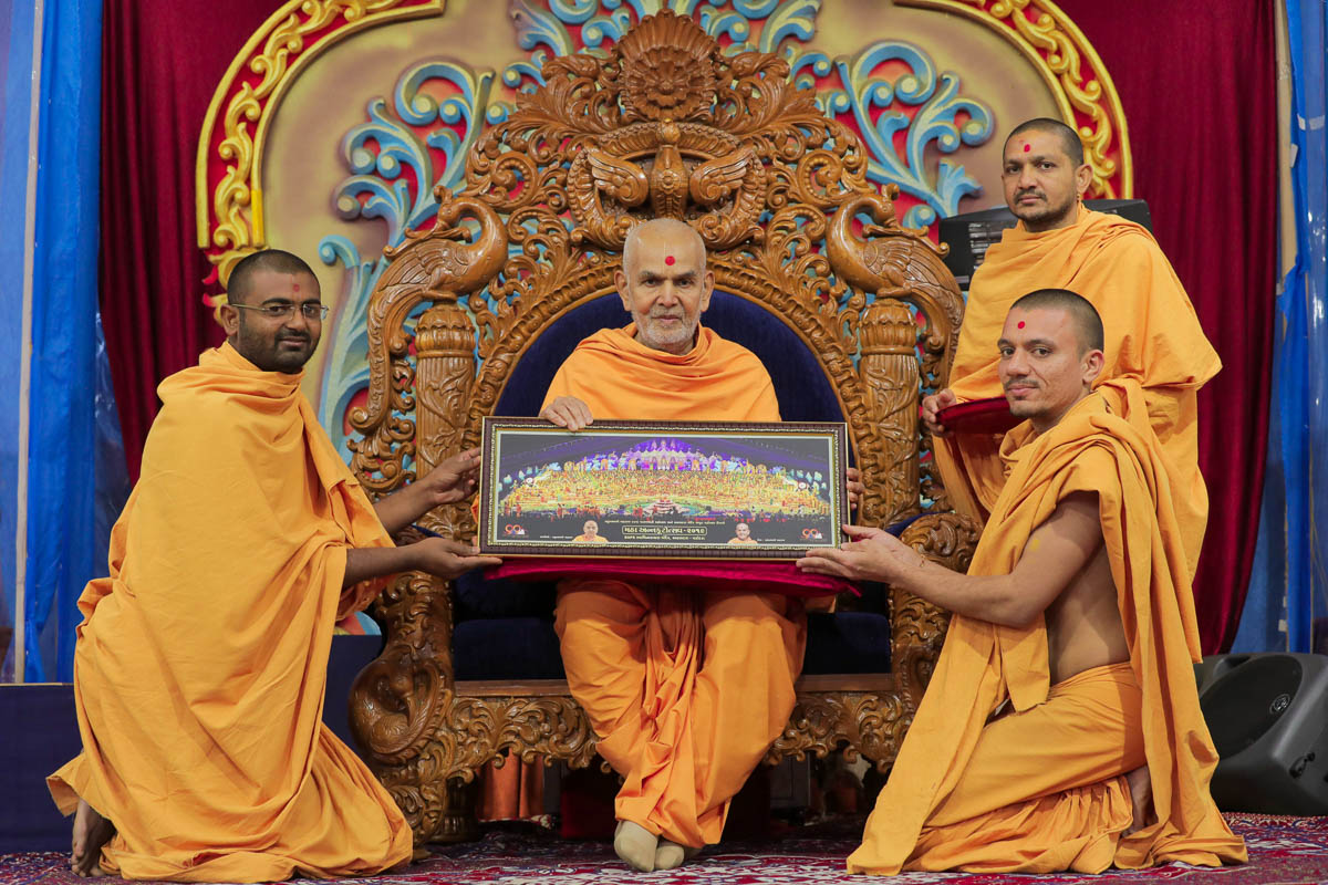 Swamishri sanctifies a photo of the maha-annakut in Atladara in October 2019