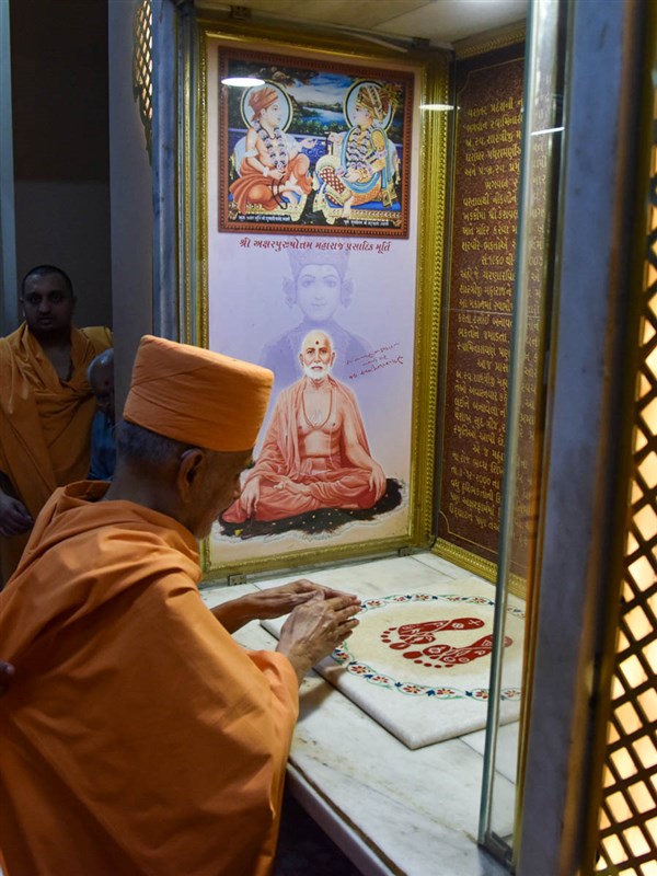 Swamishri engrossed in darshan of holy charanarvind of Bhagwan Swaminarayan